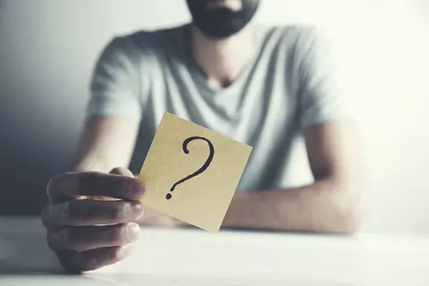 homme-tient-post-it-avec-point-d'interrogation-dans-la-caméra-questions-et-réponses