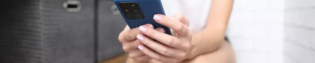 frau-sitzt-auf-der-toilette-mit-handy-in-den-händen-verstopfung-gute-verdauung
